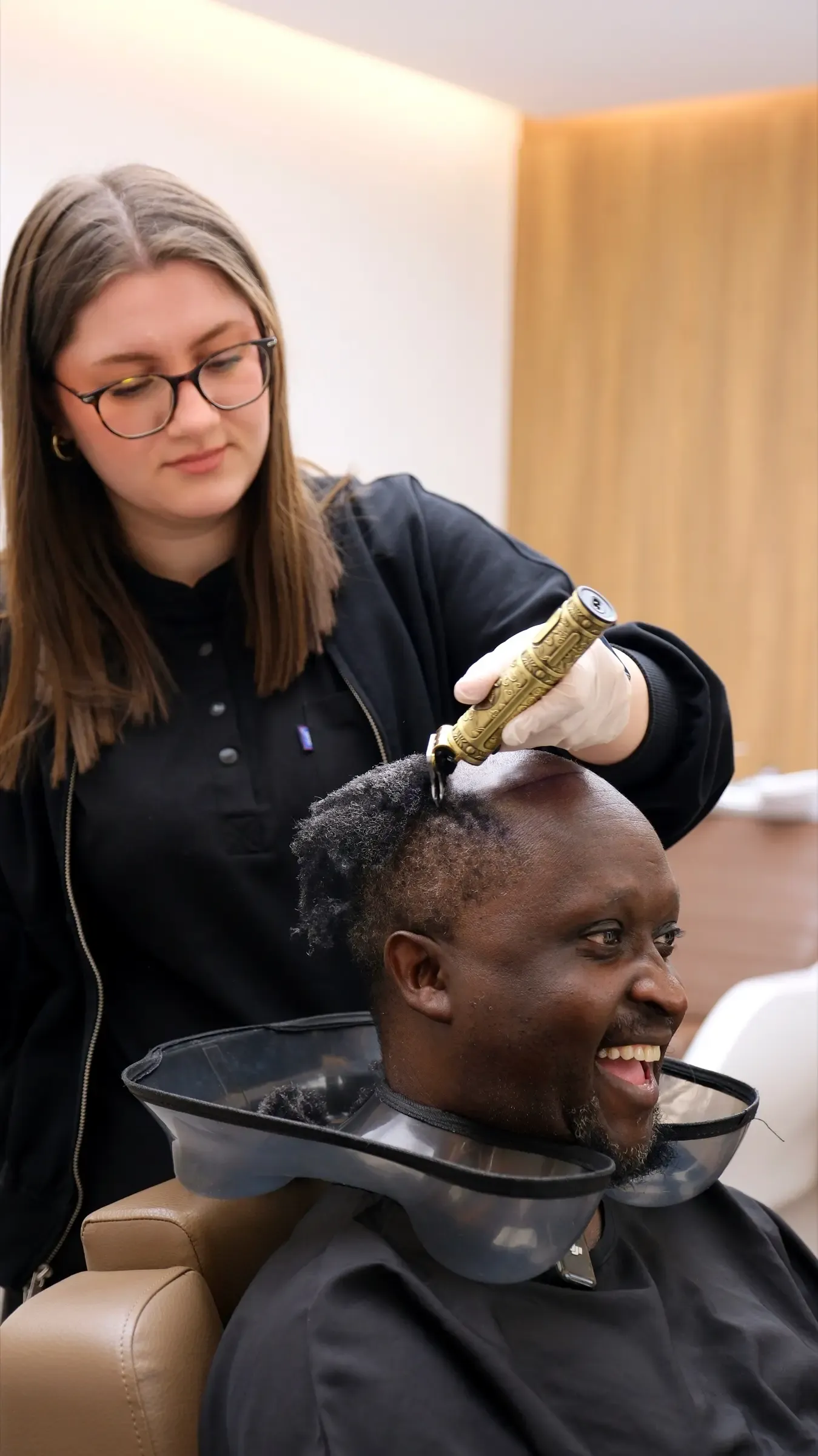A Vera Clinic nurse rinsing a patient’s scalp over a basin during an aftercare wash